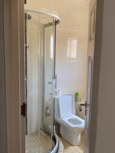 a bathroom with a toilet and a glass shower at Magville Guest House in Gaborone