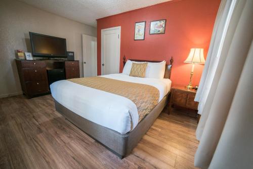 a bedroom with a large bed and a red wall at Parry Lodge in Kanab