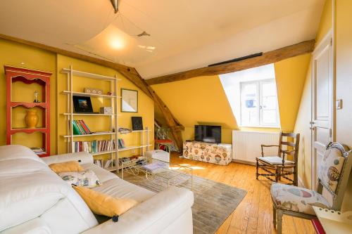 uma sala de estar com paredes amarelas e um sofá branco em Le panoramique, au centre historique de Dijon em Dijon