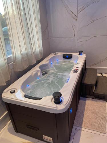 a jacuzzi tub in a bathroom with blue lights at Golden Suite - JACUZZI SAUNA in Rouen