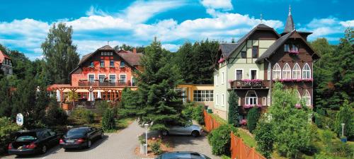 a group of houses with cars parked in a parking lot at Parkhotel Margaretenhof in Kurort Gohrisch