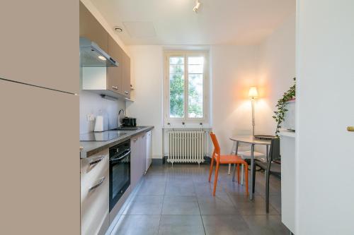 a kitchen with a table and a counter top at Le Chaussier, en plein centre ville de Dijon in Dijon