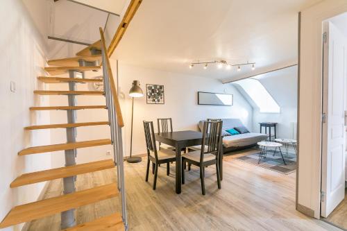 - une salle à manger et un salon avec un escalier, une table et des chaises dans l'établissement Le Godrans, en plein centre ville de Dijon, à Dijon