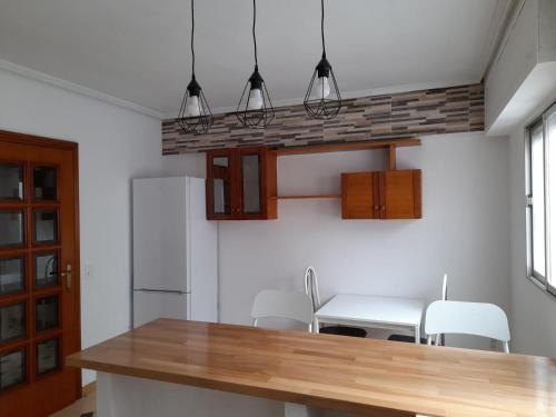eine Küche mit einer Holzarbeitsplatte und einem Tisch in der Unterkunft Torresmar home in Segorbe