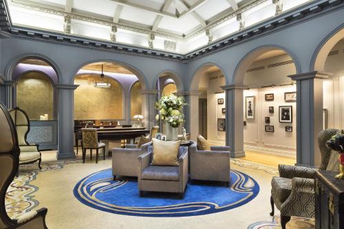 a lobby with chairs and a table in a building at La Clef Louvre Paris by The Crest Collection in Paris