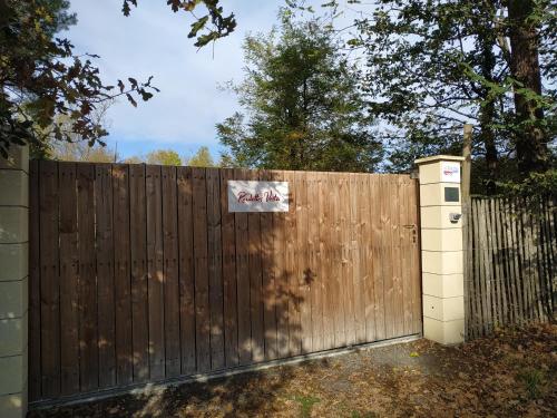 a wooden fence with a sign on it at Les roulottes Vesta in Léognan