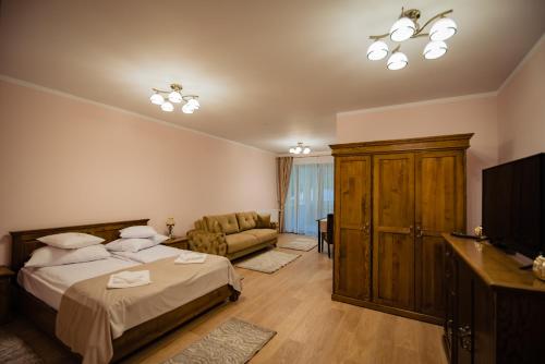 a bedroom with a bed and a tv and a couch at Casa Măiereană in Anieş