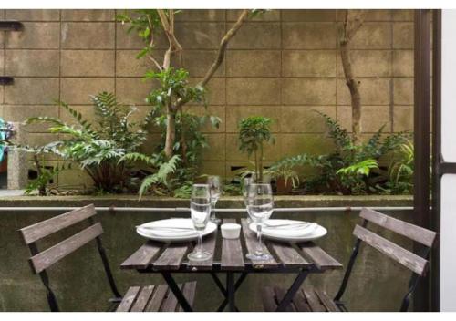 a wooden table with two chairs and wine glasses at Palace Mercy105 - Vacation STAY 11922 in Kugayama