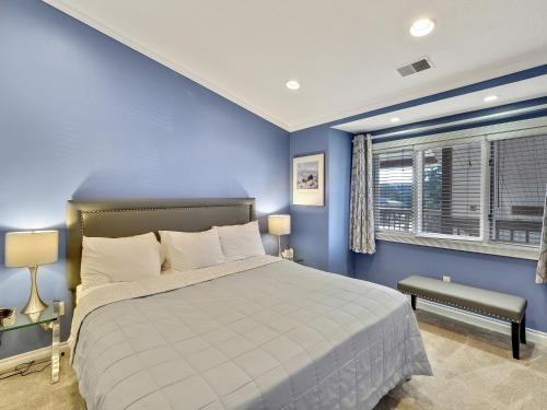 niebieska sypialnia z łóżkiem i oknem w obiekcie Beach Room 328 w mieście Traverse City