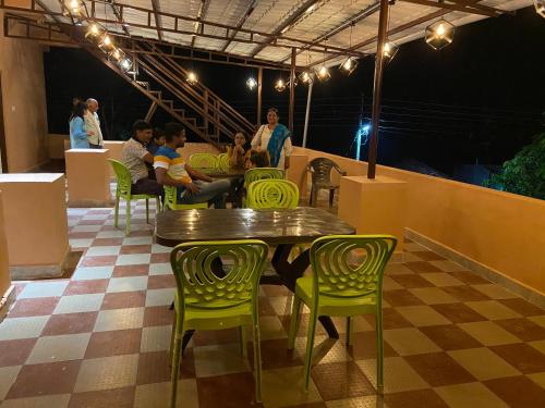 a group of people sitting around a table and chairs at Erisha Tadoba in Mohurli