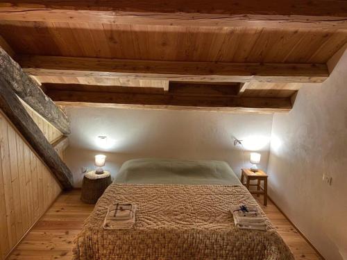 - une chambre avec un lit dans une pièce dotée de plafonds en bois dans l'établissement Al Salt, à Belluno