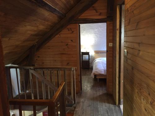 een trap in een hut met een bed in een kamer bij Maison chaleureuse in Montignac