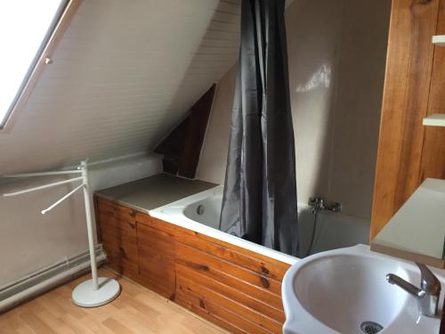 La salle de bains mansardée est pourvue d'un lavabo et d'une baignoire. dans l'établissement Maison chaleureuse, à Montignac