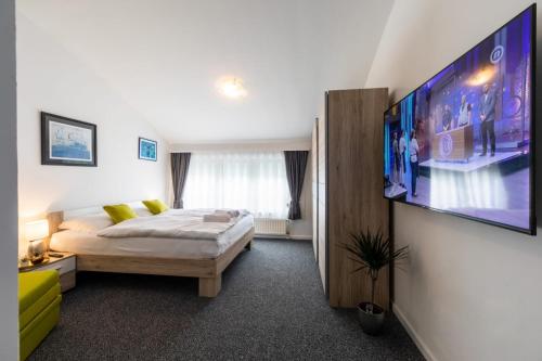 a bedroom with a bed and a flat screen tv at Four Roses in Zagreb