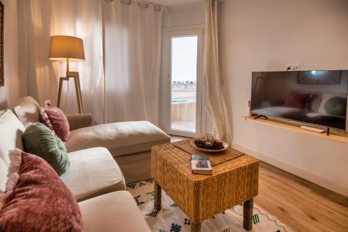 salon z kanapą i stołem w obiekcie SibsSanlucar MARITIMO-1ª Linea de Playa w mieście Sanlúcar de Barrameda