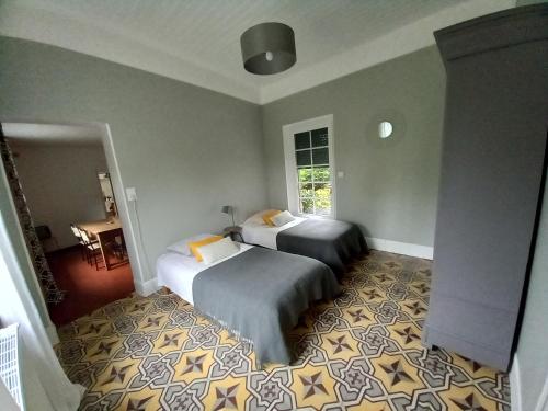 une chambre avec deux lits et une fenêtre dans l'établissement La Maison Molières, à Montauban