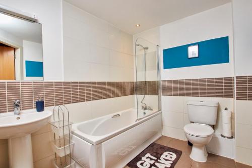 a bathroom with a toilet and a sink and a bath tub at The Sleek Nottingham Gem with Balcony - Sleeps 6 in Nottingham
