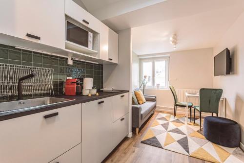 une cuisine avec un évier et un salon dans l'établissement L'arc en ciel, face à la Cathédrale - 3D, à Reims