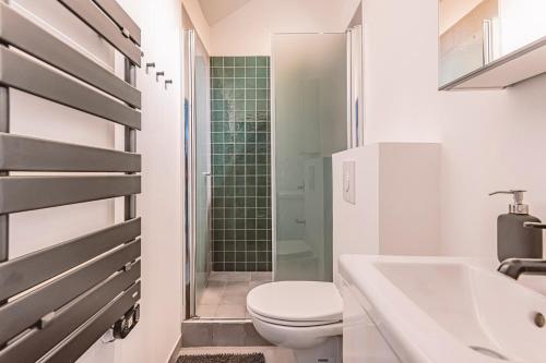 une salle de bain blanche avec des toilettes et un lavabo dans l'établissement L'arc en ciel, face à la Cathédrale - 3D, à Reims