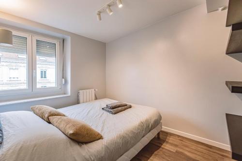 une chambre avec un lit et une fenêtre dans l'établissement L'arc en ciel, face à la Cathédrale - 3D, à Reims