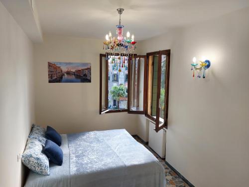 Schlafzimmer mit einem Bett und einem Kronleuchter in der Unterkunft Residenza Donini in Venice Suite 2 in Venedig