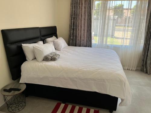 sypialnia z dużym łóżkiem z białą pościelą i poduszkami w obiekcie House 210 holiday rentals w mieście Alberton