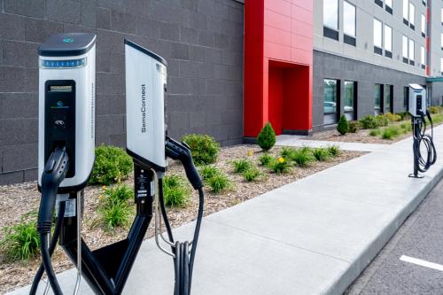 a row of solar energy machines in front of a building at avid hotels Milwaukee West - Waukesha by IHG in Pewaukee