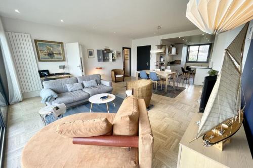 un soggiorno con divano e tavolo di LUXURY T3 neuf de standing Front de mer vue 180 a Larmor-Plage