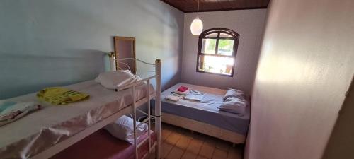 a small room with two beds and a window at Linda Chácara em IBIUNA com Sauna - Piscina - WiFi - Caseiro in Ibiúna