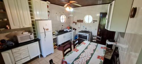 a small kitchen with a table and chairs in it at Linda Chacara em IBIUNA in Ibiúna