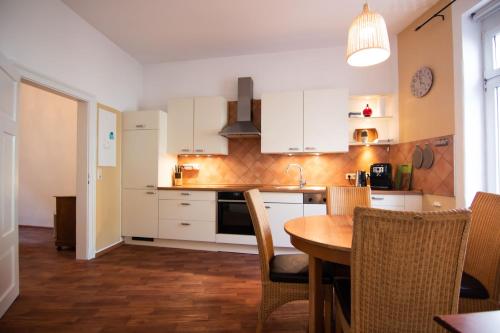 a kitchen with white cabinets and a table and chairs at Ferienwohnung „Markus“ in Bad Ems