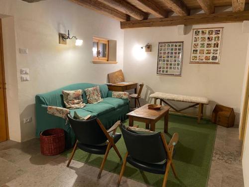 - un salon avec un canapé vert et des chaises dans l'établissement Al Salt, à Belluno