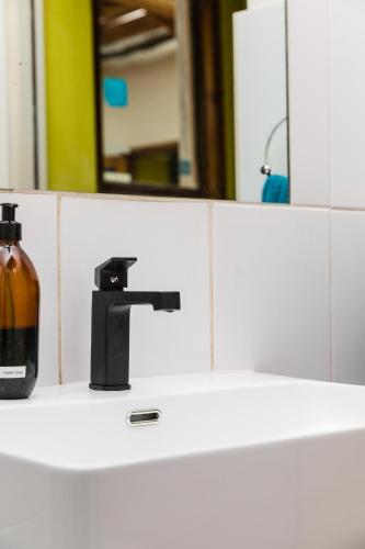 a bathroom sink with a soap dispenser and a mirror at Villa Viva Cape Town in Cape Town