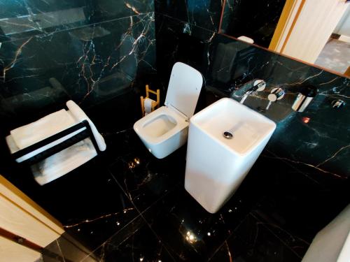 a bathroom with a white toilet and a sink at Piotrkowska.eu Apartament Romantica in Łódź