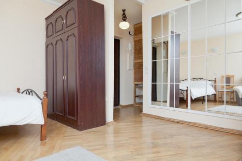 a bedroom with a large wooden door and a room with a table at KvartiraSvobodna - Apartment at Bolshoy Kondratyevskiy in Moscow