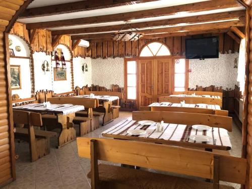a dining room with tables and chairs and a tv at Гірський узвіз in Vizhenka