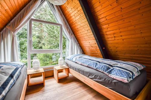 1 dormitorio con 2 camas y ventana grande en Eulenhäusle, en Schramberg