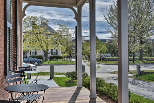 a porch with a table and benches and a street at The Burrell House in Keene
