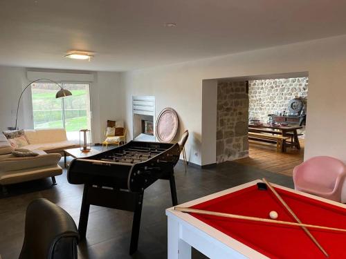 a room with a ping pong table and a living room at CASARIOU Les Bernards Villa Grande bâtisse 12p avec cheminée bain nordique billiard piscine in Vaudevant