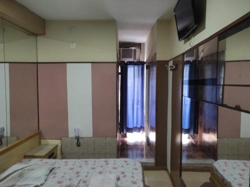 um quarto com uma cama e uma televisão na parede em Hotel Esperança AdultOnly no Rio de Janeiro