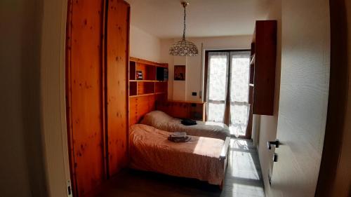 een kleine slaapkamer met 2 bedden en een raam bij Appartements Le-Z-aravì-Orazio in Aosta