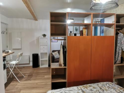 a room with a bed and a large wooden cabinet at Les appartements du centre, refaits à neuf, climatisés, hyper centre, 50m à pieds des commerces, restaurants, parking gratuit in Salies-de-Béarn