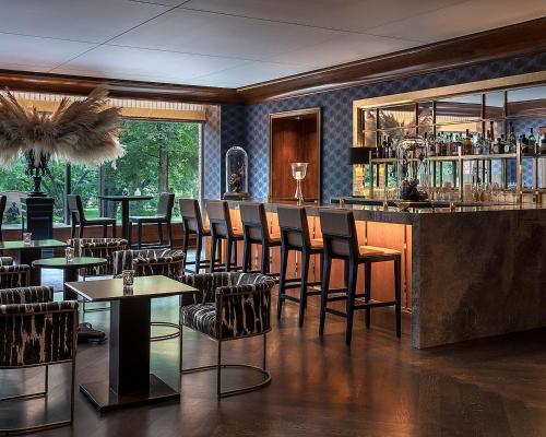 a restaurant with a bar with chairs and tables at Four Seasons Boston in Boston