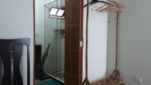 uma casa de banho com um espelho e uma cabina de duche em vidro. em Cantinho do Nick em Itanhaém