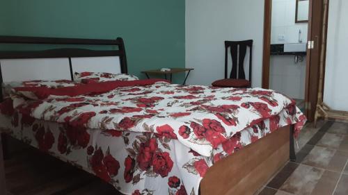 a bedroom with a bed with a red and white blanket at Cantinho do Nick in Itanhaém