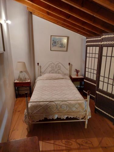 a bedroom with a bed and two tables with windows at Constantias stone houses in Lofou