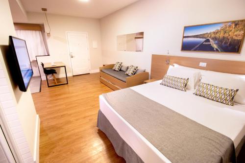 博尼图Promenade Bonito All Suites的带一张大床和一张沙发的卧室