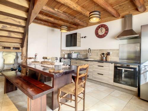 une cuisine avec une table et une horloge au mur dans l'établissement Gîte de montagne « Les Pivoines » à Nistos, à Nistos