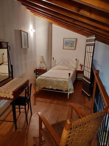 a bedroom with a bed and a table and chairs at Constantias stone houses in Lofou