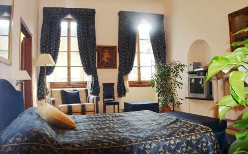 1 dormitorio con 1 cama en una habitación con ventanas en Tornabuoni La Petite Suite, en Florencia